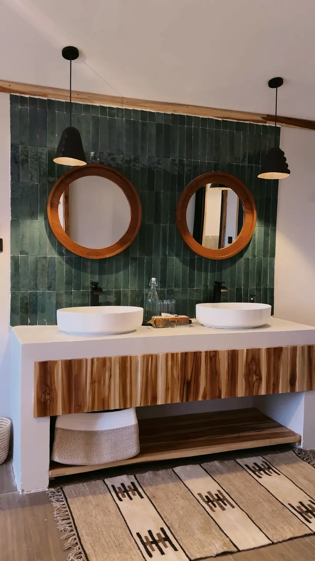 Twin circular mirrors and a timber vanity in an Elephants Lair guest bathroom