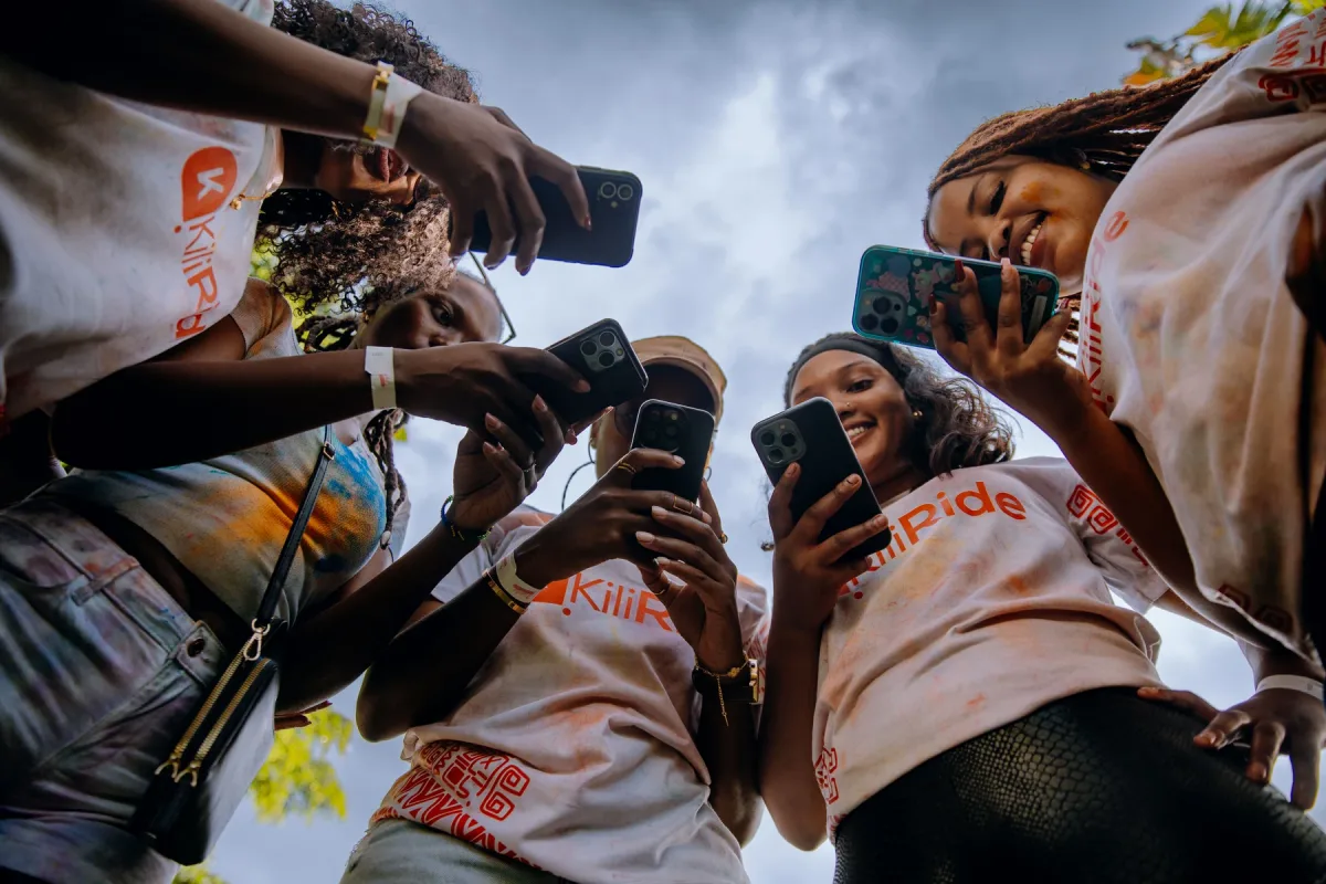 A group of event guests gathered together with their phones raised